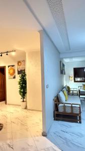 una sala de estar con un sofá y un televisor en appartement équipé, en Tánger