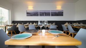 - une table en bois avec des assiettes et des verres à vin dans l'établissement Quays Hotel, à Batemans Bay