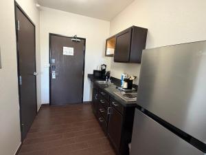a kitchen with a stainless steel refrigerator and a sink at Black Gold Suites Stanley in Stanley +14 photos