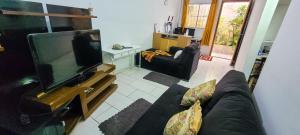 a living room with a couch and a flat screen tv at Casa 2000 Positivo UTFPR INC Volvo in Curitiba