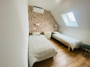 a small bedroom with two beds and a window at Le Grand Francillon in Villebarou
