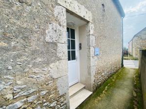 a door in the side of a stone building at Le Grand Francillon in Villebarou