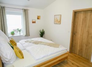 a bedroom with a bed with white sheets and a window at Ferienwohnung Schusternagerl in Simbach