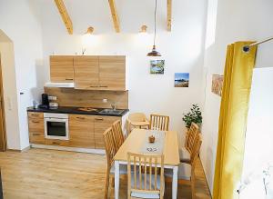a kitchen and dining room with a table and chairs at Ferienwohnung Schusternagerl in Simbach