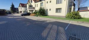 a cobblestone street with a car parked in front of a house at Morena in Klaipėda