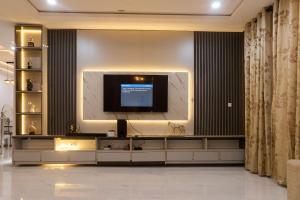 a living room with a television on a wall at Buddy's Court Luxury 5Bedroom,3 & 2bed Apartment in Ikeja
