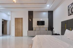 a bedroom with a bed and a tv on a wall at Buddy's Court Luxury 5Bedroom,3 & 2bed Apartment in Ikeja +1 photo