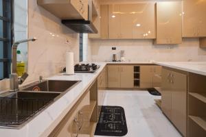 a large kitchen with a sink and a stove at Buddy's Court Luxury 5Bedroom,3 & 2bed Apartment in Ikeja