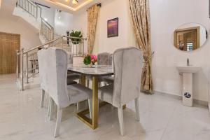 a dining room with a table and chairs at Buddy's Court Luxury 5Bedroom,3 & 2bed Apartment in Ikeja