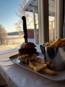 a sandwich and french fries on a plate with a knife at Hotelli Pihkuri in Viitasaari