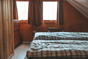 ein Schlafzimmer mit zwei Betten, einer Kommode und zwei Fenstern in der Unterkunft Solyun in Hol