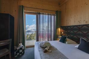 a bedroom with a large bed with a large window at L'Aiguille Grive Chalets Hotel in Arc 1800 +58 photos