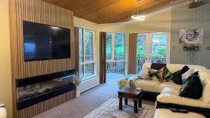 a living room with a couch and a flat screen tv at Cheerful 3 bedroom Lodge At White cross Bay Windermere in Windermere