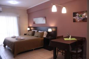 a bedroom with a bed and a table and a tableablish at Antares Apartments in Campana