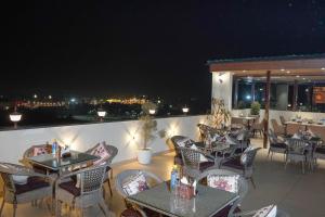 a restaurant with tables and chairs on a balcony at night at The Aero Lounge Hotel 2kms From Airport in Amritsar