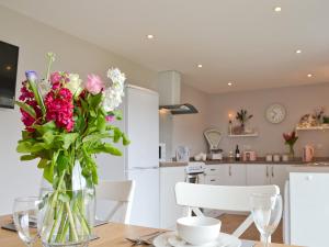 a vase of flowers on a table in a kitchen at Llifon in Llanwnda