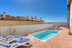 a swimming pool with lounge chairs next to a fence at Villa Perdices in Fuengirola