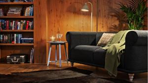 a living room with a couch and a book shelf at Hotel Bergsonne Allgäu in Sonthofen