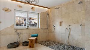 a bathroom with a shower and a bench and a window at Hotel Bergsonne Allgäu in Sonthofen +37 photos