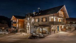 a large house with lights on in the night at Hotel Bergsonne Allgäu in Sonthofen