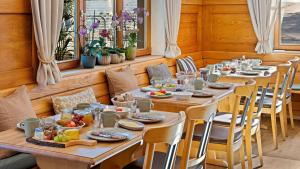 a long wooden table with plates of food on it at Hotel Bergsonne Allgäu in Sonthofen