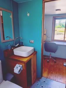 a bathroom with a sink and a desk with a chair at Tiny House 3 En el río in Linares