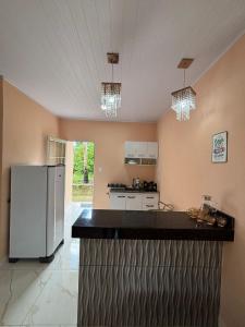 a kitchen with a white refrigerator in a room at Pousada Bela Rosa in Santa Cruz Cabrália