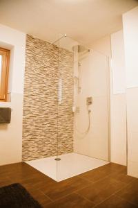 a shower with a glass door in a bathroom at Lü de Terza in San Vigilio Di Marebbe +37 photos