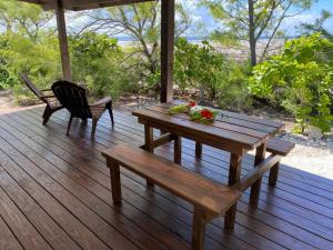a wooden table and bench on a wooden deck at Rangiroa Reef Lodge in Rangiroa