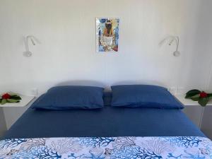 a bedroom with a blue bed with two blue pillows at Rangiroa Reef Lodge in Rangiroa
