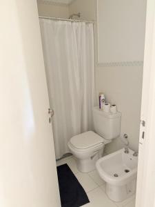 a white bathroom with a toilet and a sink at Cabildo Apart Familiar in Santiago del Estero +5 photos