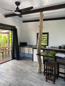 a kitchen with a table and a ceiling fan at Rangiroa Reef Lodge in Rangiroa +6 photos
