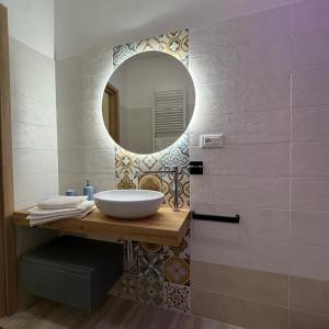 ein Badezimmer mit Waschbecken und Spiegel in der Unterkunft A Piè Piazza in Barisciano