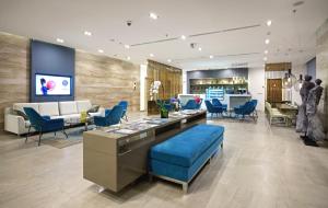 a lobby with blue chairs and a waiting room at Novotel Suites Hanoi in Hanoi