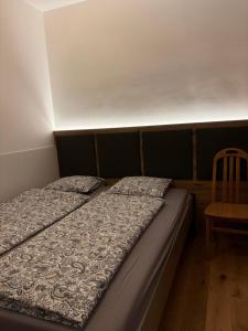 a bed in a small room with a chair and a bed sidx sidx at Apartment Lisa Hinterstoder in Hinterstoder
