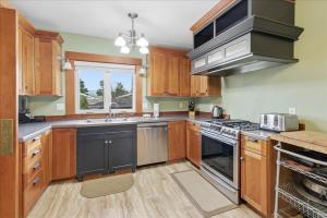 a kitchen with wooden cabinets and stainless steel appliances at Coastal Craftsman in Pacific City