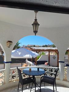 a patio with a table and chairs and an umbrella at casa des loups in Ciudad Quesada