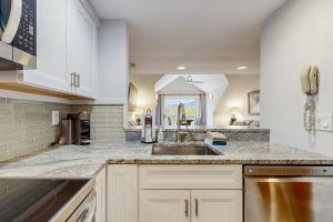 a kitchen with white cabinets and a sink at Loon Landing at Rivergreen in Lincoln