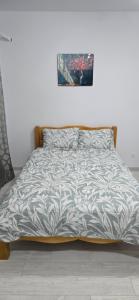 ein Bett mit einer Bettdecke darauf in einem Schlafzimmer in der Unterkunft Studio Ajustorului rezidence ,Lacu Morii in Bukarest