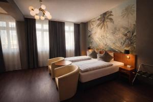 a bedroom with a bed and a painting on the wall at Hotel Bayrischer Hof in Heidelberg