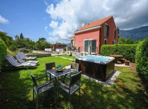 a backyard with a hot tub and a table and chairs at Villa Anita in Gruda