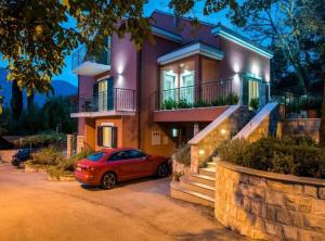 a red car parked in front of a house at Villa Anita in Gruda