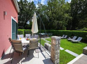 a patio with a table and chairs and an umbrella at Villa Anita in Gruda