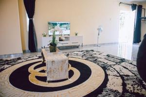 a living room with a potted plant on a rug at L a Grande deluxe in Benoni