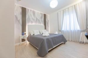 a white bedroom with a bed and a window at Aurum Pompei Suites in Pompei