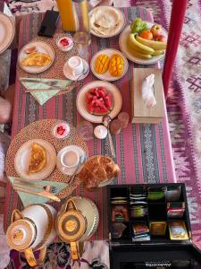 a table topped with plates of food and fruit at Just For You Starwatching Tent in Al Wāşil