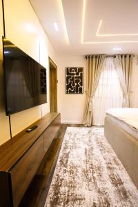 a bedroom with a bed and a flat screen tv at Avenue 28th Apartment in Benin City