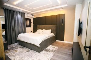a bedroom with a bed and a flat screen tv at Avenue 28th Apartment in Benin City