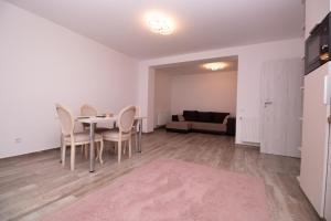 a dining room with a table and chairs and a couch at White Valey Retreat One in Buşteni