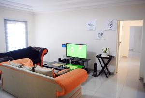 a living room with a couch and a tv at Twinhome Inn in Gaborone